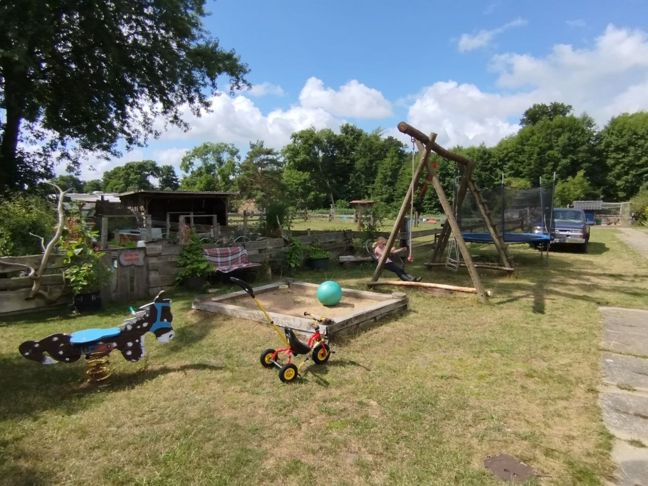Spielplatz mit Schaukel, Sandkasten und Trampolin